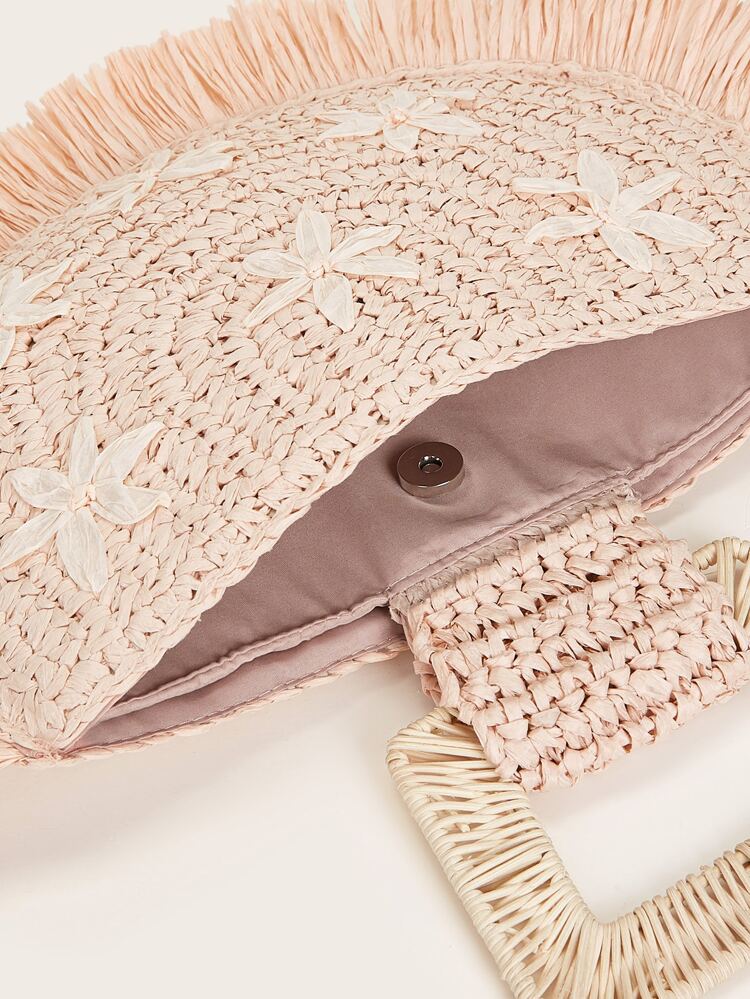 light pink straw bag with woven top handle with floral detail in front